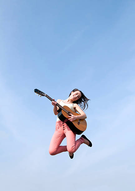 mulher pulando e tocando guitarra - freiluftkonzert - fotografias e filmes do acervo