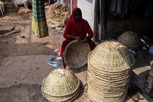 Rice basket-making process manually by using the traditional way. This image was captured on May 29, 2022, From Gabtali, Dhaka, Bangladesh.