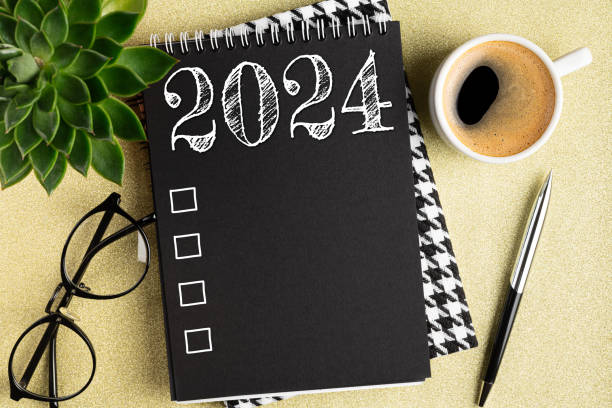 istock New year resolutions 2024 on desk. 2024 resolutions list with notebook, coffee cup on table. Goals, resolutions, plan, action, checklist concept. New Year 2024 template 1792575014