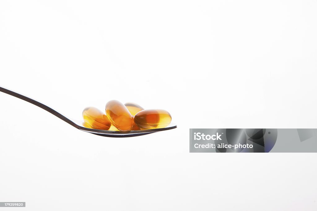 Vitamines capsules d'huile de poisson cuillère sur fond blanc - Photo de Antioxydant libre de droits