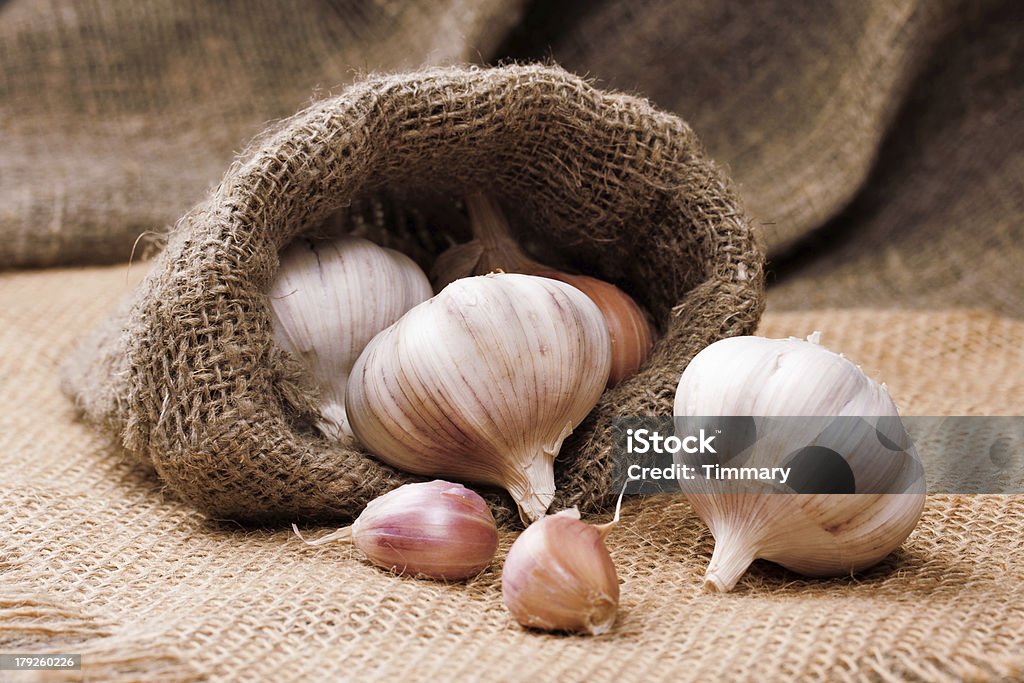 Fragrant garlic on background of coarse cloth Bag Stock Photo