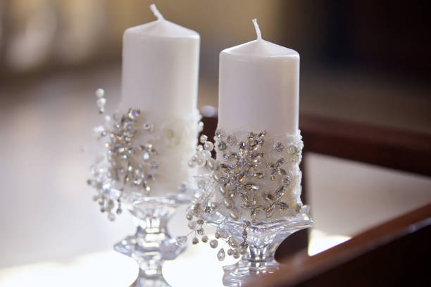 Trio of burning candles embossed with bamboo leaves, in basket with pebbles. Horizontal image.