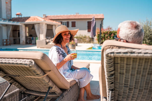 Senior Hispanic Couple Enjoying Deckchairs with Cool Drinks
