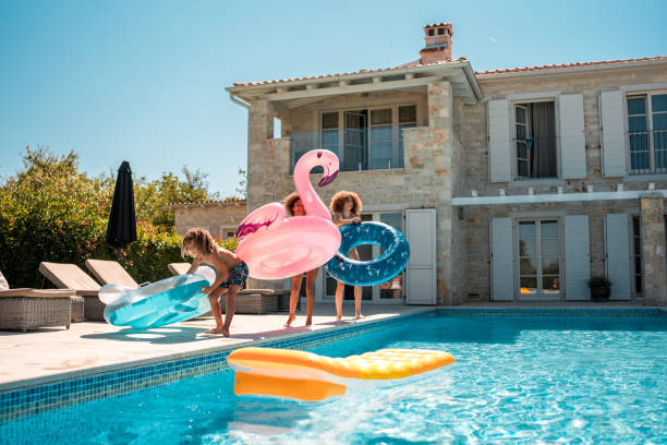 istock Young Mixed Race Boy and Sisters Enjoying Floatie Fun by the Pool 1792608255
