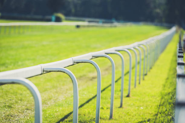istock Empty horse race track with green grass and white fence 1792608926