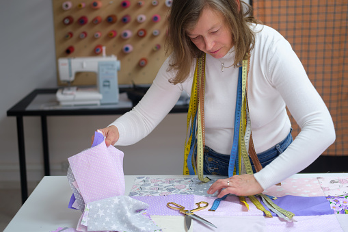 Fashion designer woman working on her designs in the studio at the table