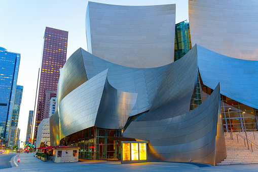 Low-angle medium shot of a gleaming graceful glass section of the distinctive Walt Disney Concert Hall in Los Angeles