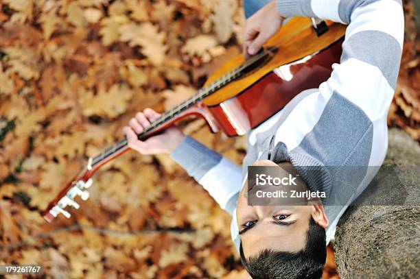 Giovane Uomo Con Chitarra Nel Parco - Fotografie stock e altre immagini di Abiti pesanti - Abiti pesanti, Adolescente, Adolescenza