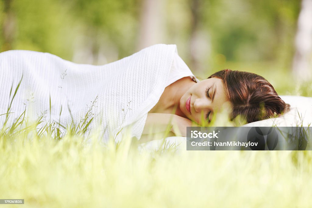 Kobieta spanie na trawie - Zbiór zdjęć royalty-free (Biały)