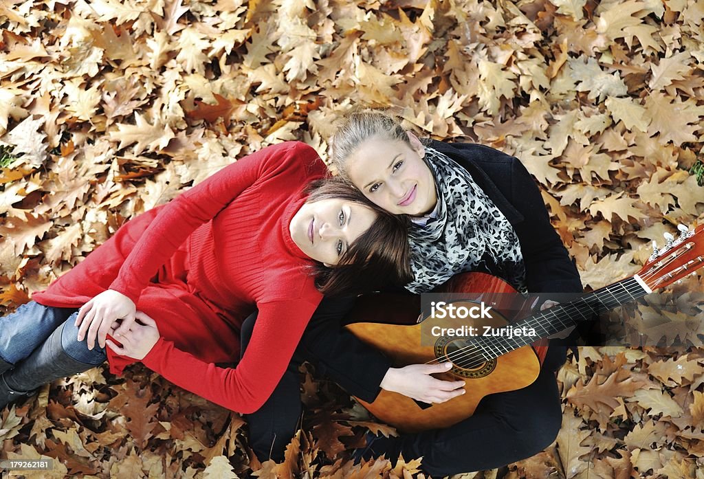 Due ragazza Suona la chitarra e avendo buon tempo nella natura - Foto stock royalty-free di Adolescente