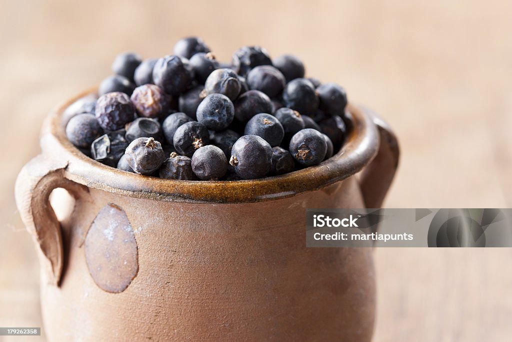 Pile of juniper berries on ceramic bowl Pile of juniper berries on ceramic bowl close-up Berry Stock Photo