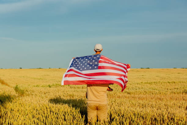 istock Father with son and USA flag on wheat field 1792625363