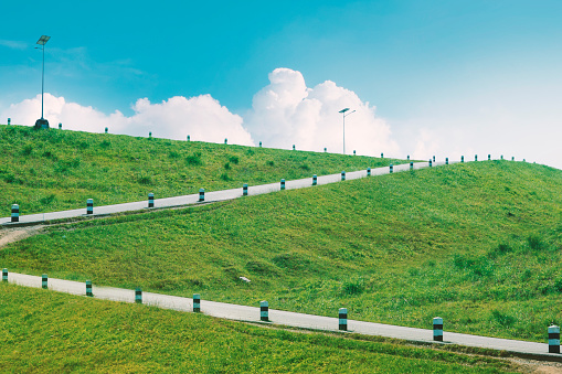 Road stairs on hill, meadow and blue sky, beautiful landscape.
