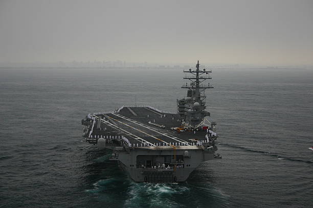 Aircraft Carrier off San Diego The USS Ronald Reagan returning to port after a deployment. The Sailors are manning the rails. us navy stock pictures, royalty-free photos & images