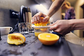 Teenage boy is preparing orange juice