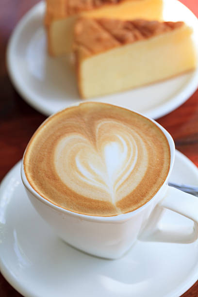 Cup of latte coffee with cake on table