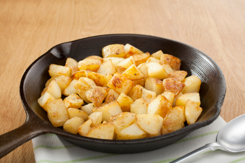 A small cast iron skillet or frying pan filled with home fries or saute potatoes. More breakfasts:-