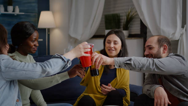 istock Mixed race friends chatting during night party while sitting on sofa 1792659903