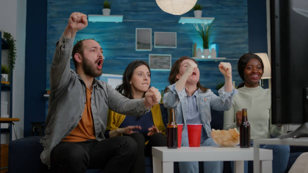istock Mixed race friends relaxing on couch while watching football game 1792660970