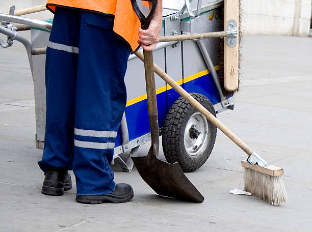 Photo of man in uniform cleaning street "Image of a street cleaner in Trafalgar Square, London" street sweeper stock pictures, royalty-free photos & images