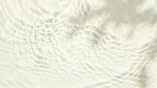 Top view background summer natural  Beige surface, clear water with ripples and splashes. water waves in sunlight The water surface has waves and concept background  cosmetics moisturizer toner