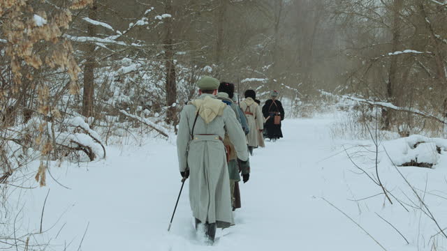 Historical Reenactment. Men Dressed As White Guard Soldiers Of Imperial Russian Army In Russian Civil War s Marching Through Snowy Winter Forest