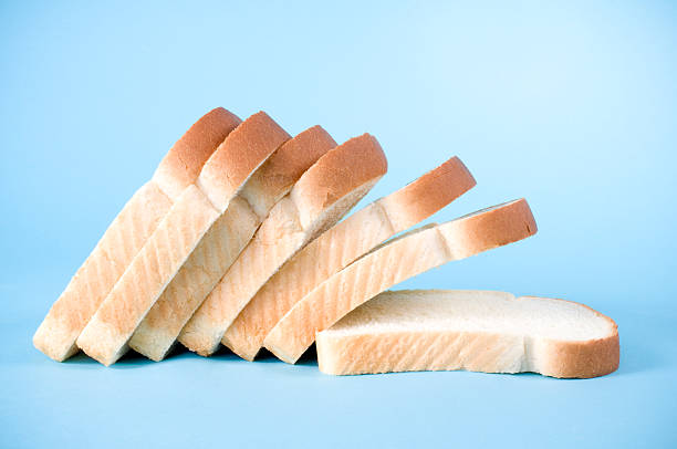 Slices of white bread on a blue background stock photo