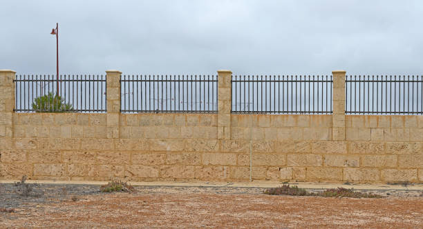 istock Concrete block wall with fence 1792695489