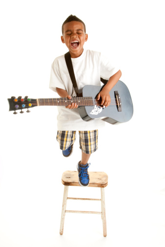 Little boy singing his heart out with guitar.