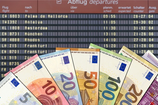 Symbolic image: Euro bills in front of the scoreboard in the airport