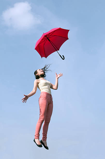istock woman jumping with red umbrella 179270836
