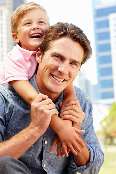 istock Man sitting in city park with young son 179271428