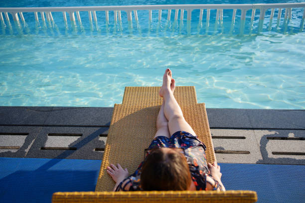 Teenage girl relaxing in a hotel pool with a panoramic view of the Indian ocean, Maldives