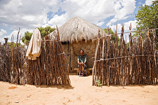 basarwa man "One of the few remaining bushman sitting down in front of his traditional shack, the indigenous people of Kalahari." bushmen stock pictures, royalty-free photos & images