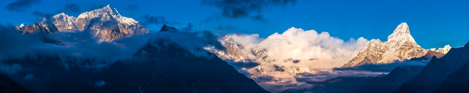 Mt. Everest, Nuptse and Lhotse glowing in the golden light of sunset overlooked by Ama Dablam guarding the Khumbu valley high in the Himalayan mountains of Nepal.