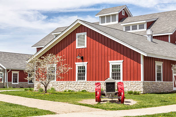 Red barn behind white fence in rural Maine