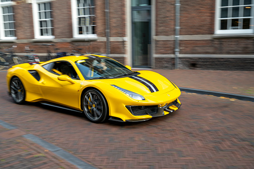 Ferrari 488 Pista sports car in the streets of Zwolle. The Pista is a high performance version of the Ferrari 488 GTB sports car. Panning photo with heavy motion blur.