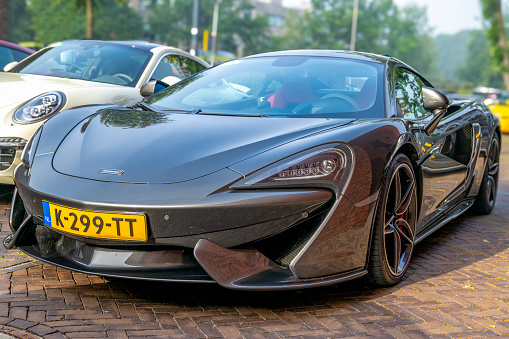 McLaren 570S sports car parked on a street in Zwolle, Netherlands. The McLaren 570S is a high-performance sports car produced by McLaren Automotive, a British manufacturer of luxury sports cars and supercars. The 570S is powered by a mid-mounted, 3.8-liter twin-turbocharged V8 engine. The body design is aerodynamically efficient, providing both performance and aesthetic appeal.