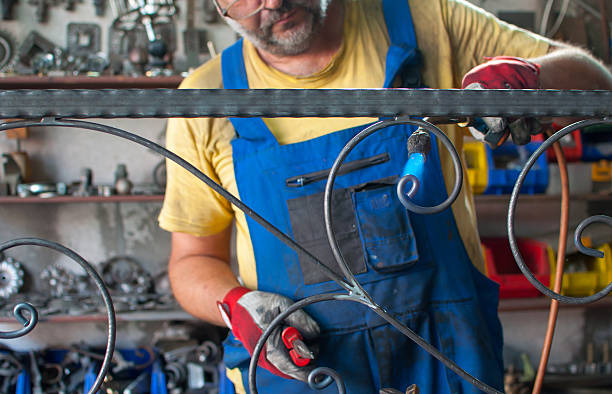 istock craftsman heats iron with welding torch 179275850
