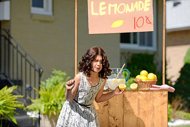 criança fazendo cara segurando limão azedo - retro revival lemonade stand old fashioned lemonade imagens e fotografias de stock