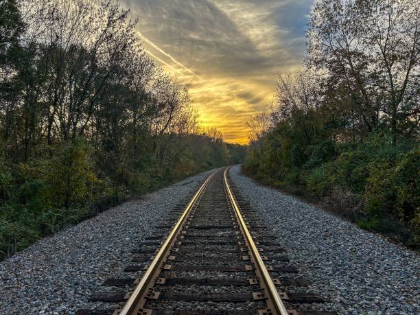 istock an empty railway track with the sun setting behind it and a small hill to the 1792779293