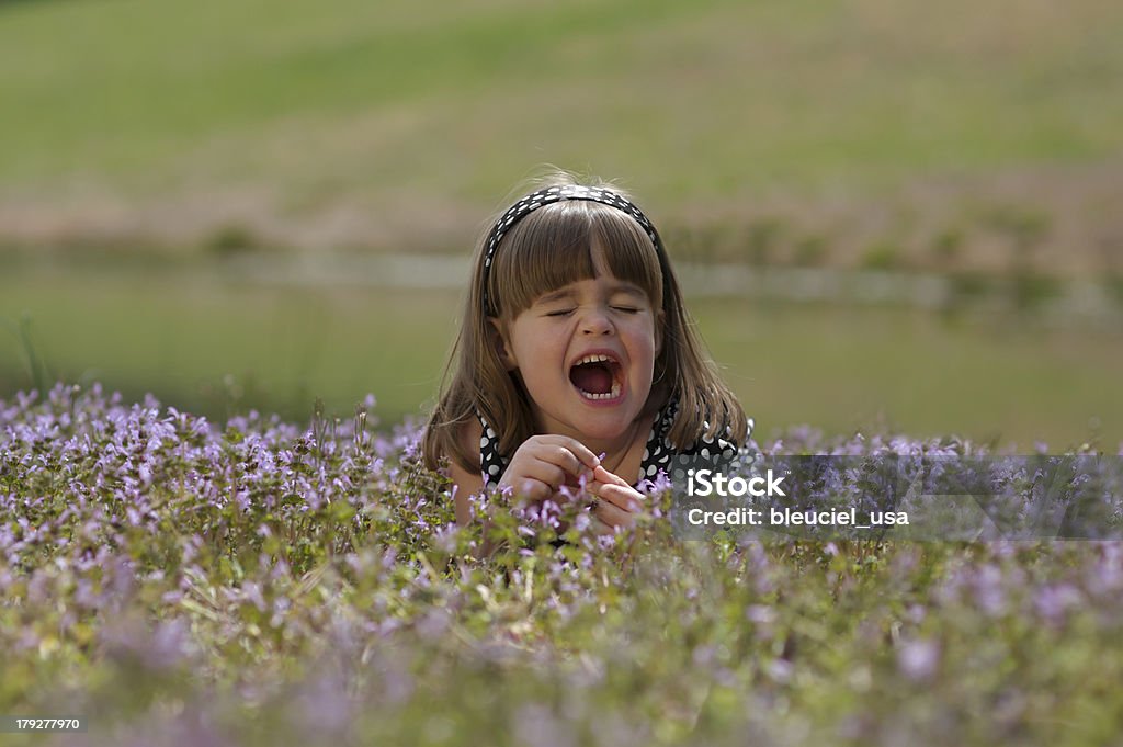 Petite fille éternuer dans un champ de fleurs sauvages - Photo de Champ libre de droits