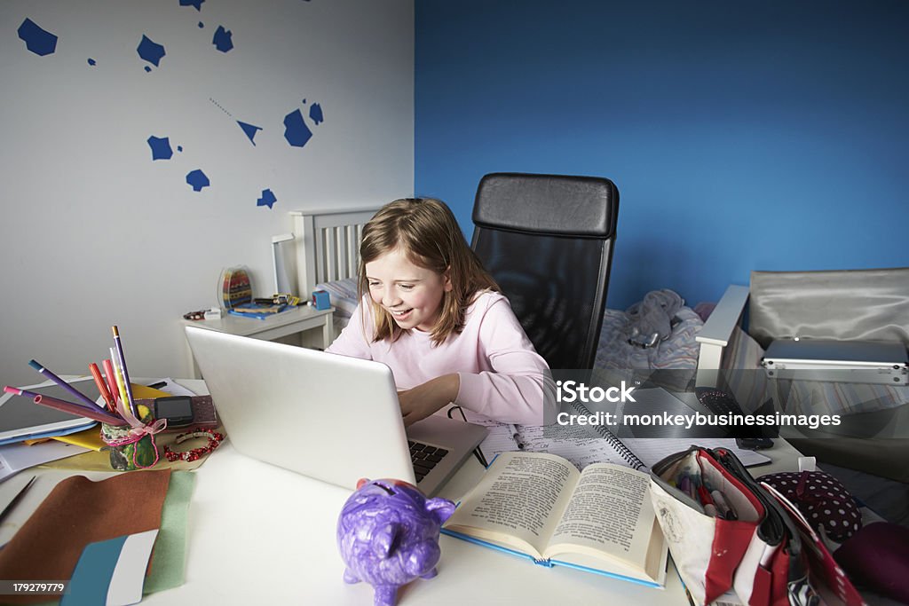 Fille étudiant à l'aide d'un ordinateur portable dans la chambre - Photo de 8-9 ans libre de droits