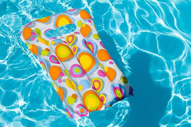 Inflatable mattress floating in swimming pool