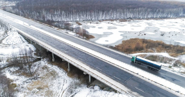 luftverkehr winterverkehrsdrohne landschaft straße vereist - drivers point of view country road snowing blizzard stock-fotos und bilder