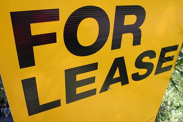 Black letters of FOR LEASE on yellow signboard stock photo