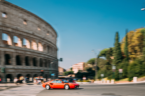 Rome, Italy - October 21, 2018: Red Ferrari Mondial Coupe In Fast Motion Near Colosseum.