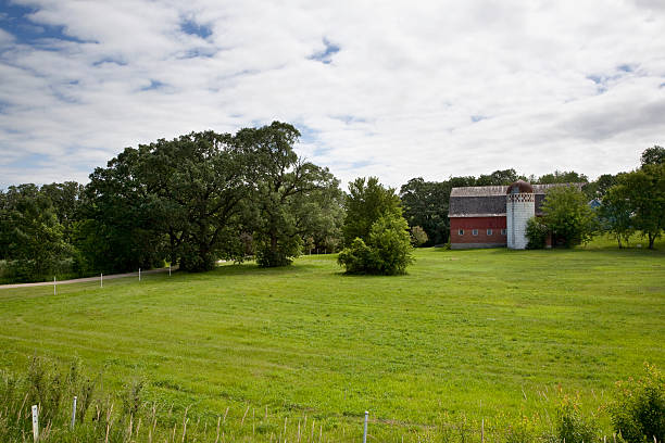 istock Red barn in sunlit green field 179283369