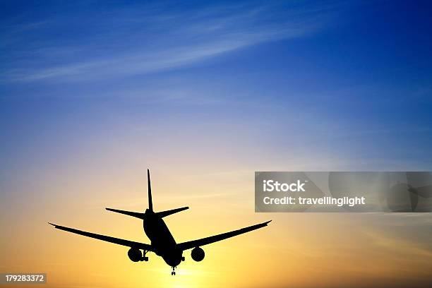 Jet Avión Aterrizaje De Silueta Al Atardecer Azul Amarillo Espacio De Copia Foto de stock y más banco de imágenes de Aire libre