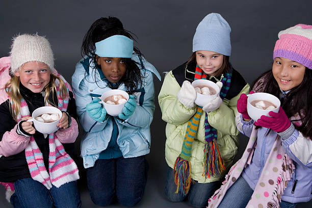 Hot Chocolate Three young girls are all bundled up and drinking mugs of hot chocolate. kids winter coat stock pictures, royalty-free photos & images